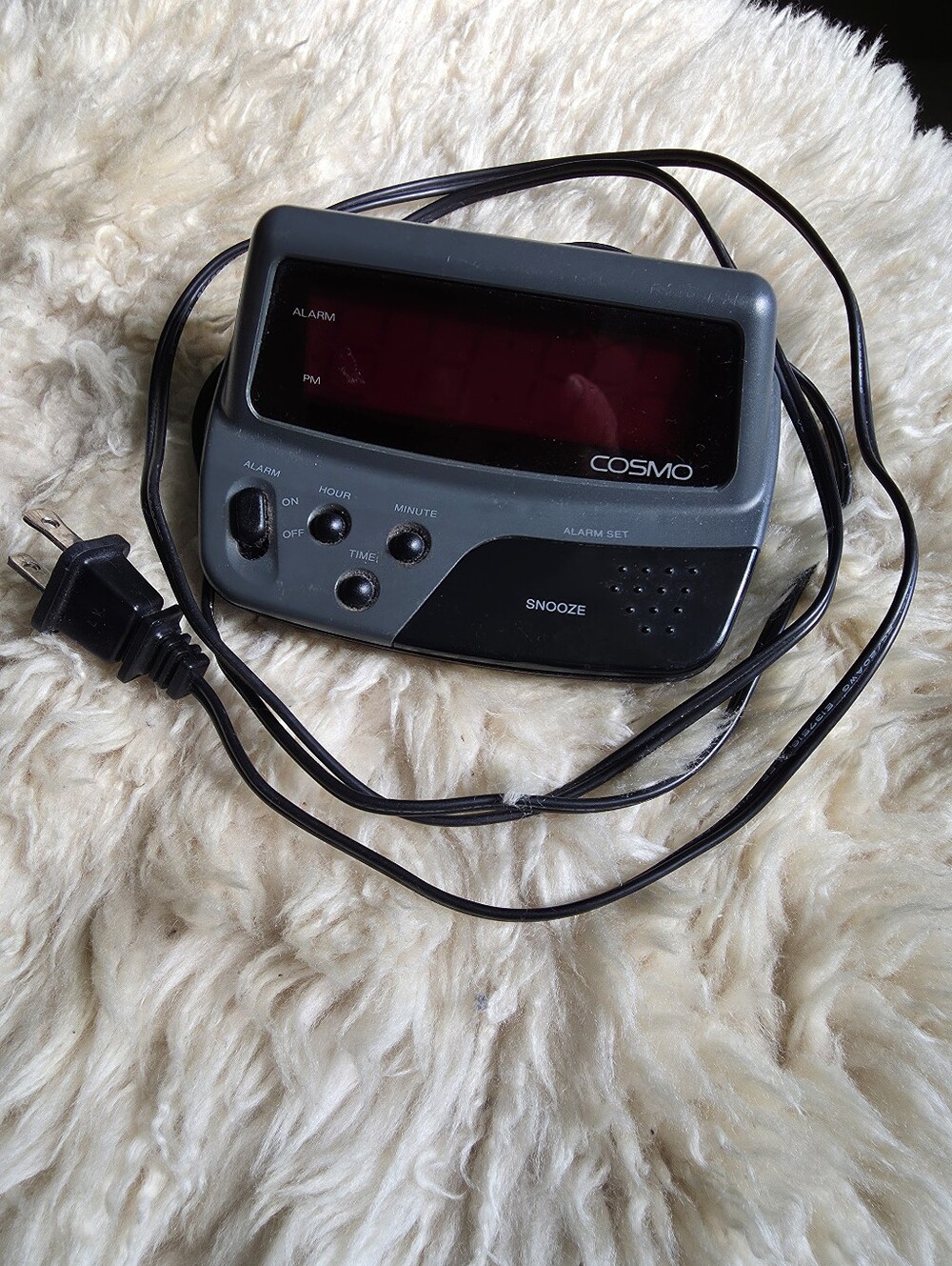 Vintage Cosmo digital alarm clock with a grey and black plastic casing.